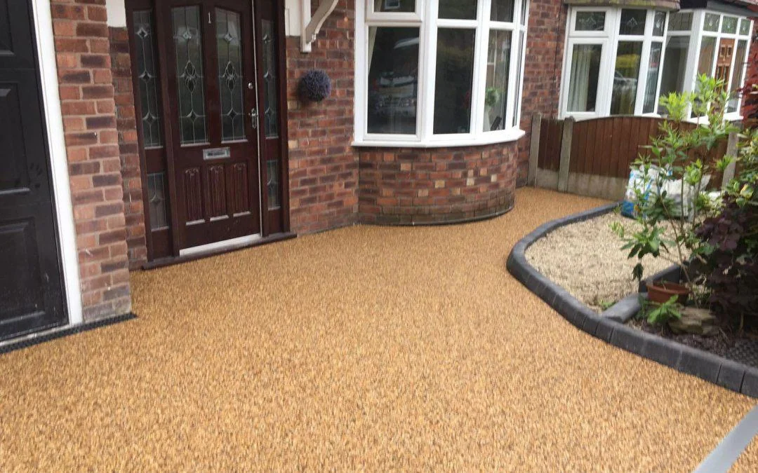 Golden resin entrance curving past a planted bed and brick porch