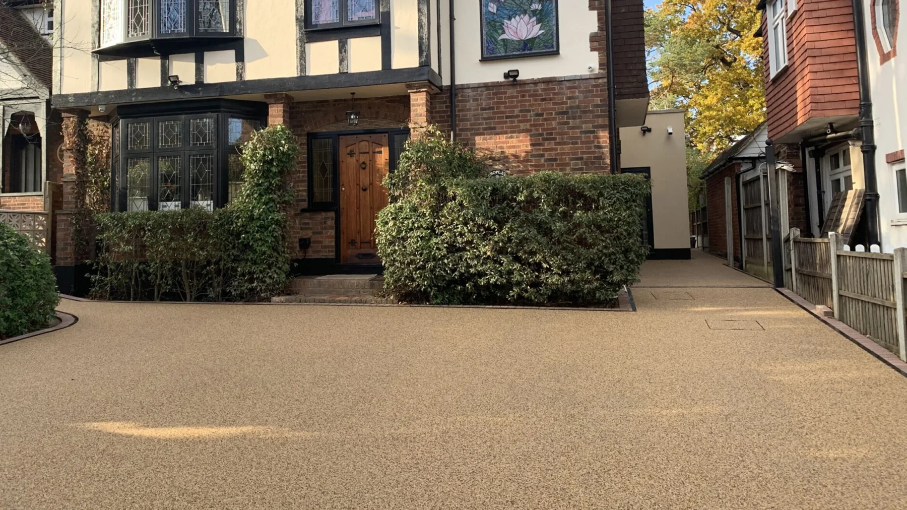 Golden resin driveway beside a traditional timber-fronted house
